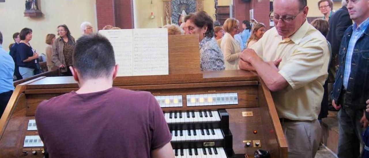 Joaquín Álvarez Arias, ayer, tocando el órgano ante la atenta mirada de los fieles de la parroquia de Lugones.