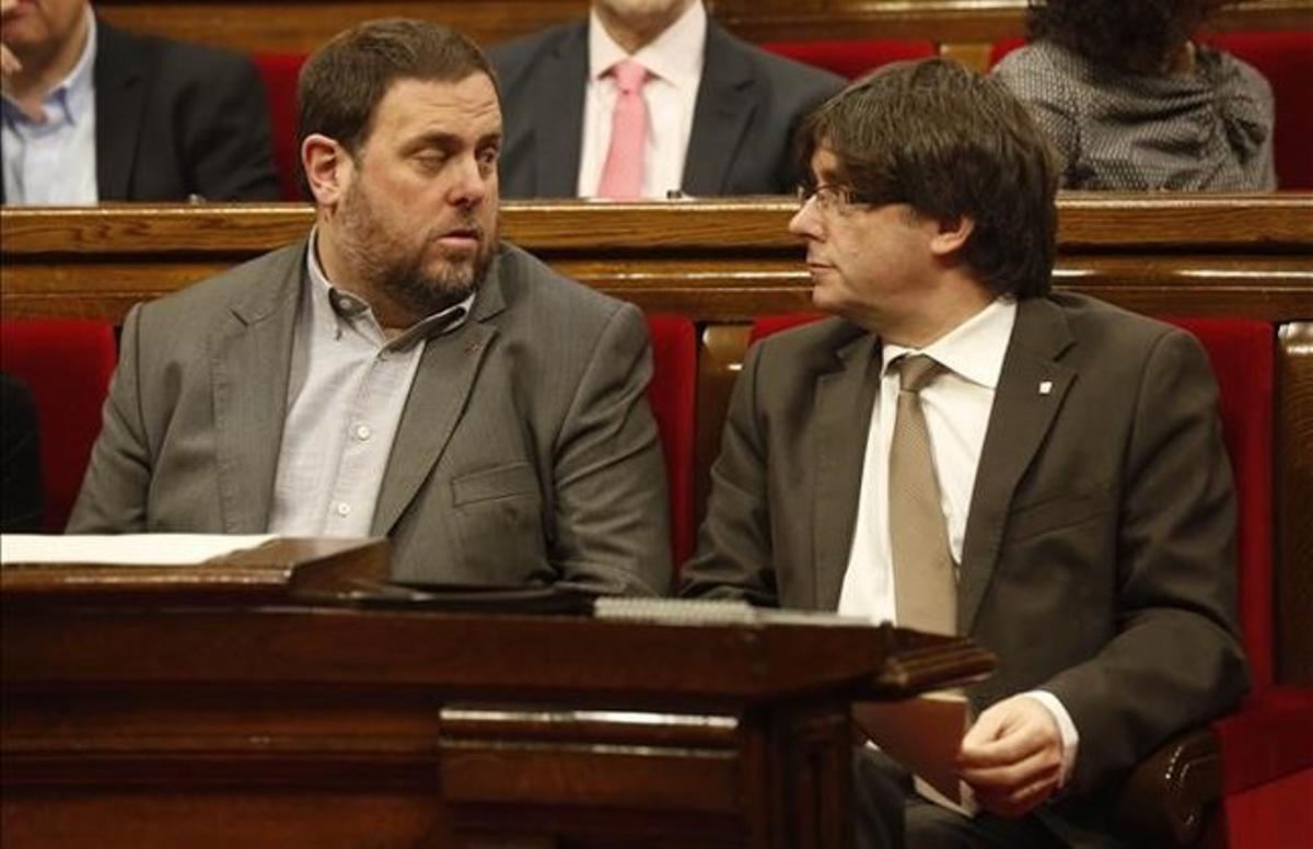 El President de la Generalitat, Carles Puigdemont junto a Oriol Junqueras en el Ple del Parlament