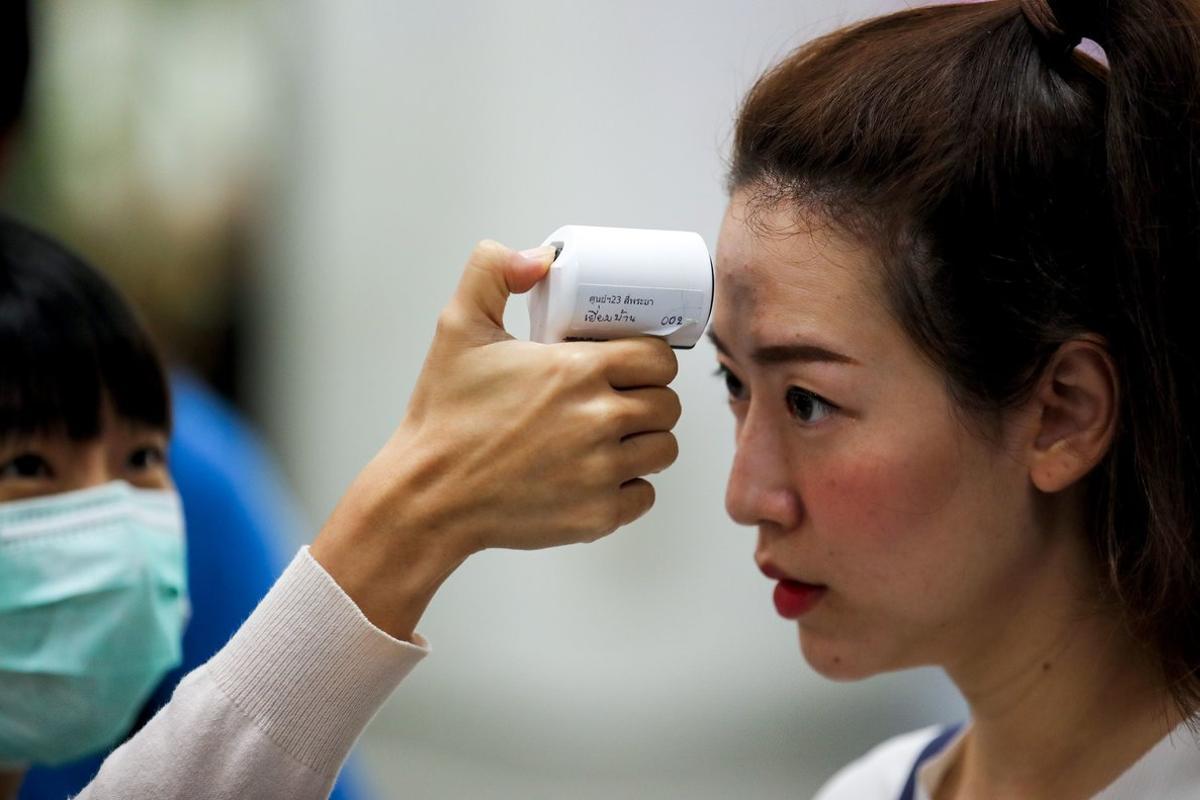 Bangkok (Thailand), 14/02/2020.- A Thai woman wearing a protective mask checks the temperature of a woman at a marriage registry in Bangkok, Thailand, 14 February 2020. Thai Public Health officials said that the number of people infected with the deadly coronavirus or COVID-19 in Thailand remained at 33. Nine had been discharged from hospitals. The virus has so far killed at least 1,360 people and infected nearly 60,000 others worldwide, mostly in China. (Tailandia) EFE/EPA/DIEGO AZUBEL