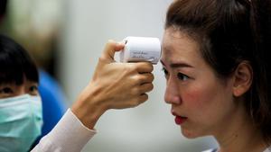 Bangkok (Thailand), 14/02/2020.- A Thai woman wearing a protective mask checks the temperature of a woman at a marriage registry in Bangkok, Thailand, 14 February 2020. Thai Public Health officials said that the number of people infected with the deadly coronavirus or COVID-19 in Thailand remained at 33. Nine had been discharged from hospitals. The virus has so far killed at least 1,360 people and infected nearly 60,000 others worldwide, mostly in China. (Tailandia) EFE/EPA/DIEGO AZUBEL
