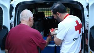 El voluntario José Antonio sirve gazpacho a una de las personas sin hogar en la zona de la Avenida Cádiz.