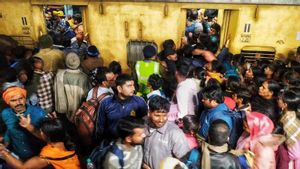 Pasajeros se empujan para subir a un tren en la estación de Nueva Delhi, India.