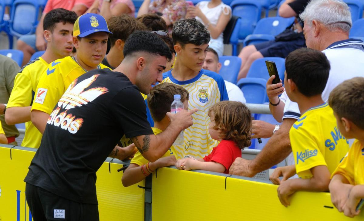 Alberto Moleiro, vestido de calle porque estaba lesionado, se fotografía con niños en la previa del partido entre la UD Las Palmas y la Real Sociedad el pasado 25 de septiembre. | | JOSÉ CARLOS GUERRA