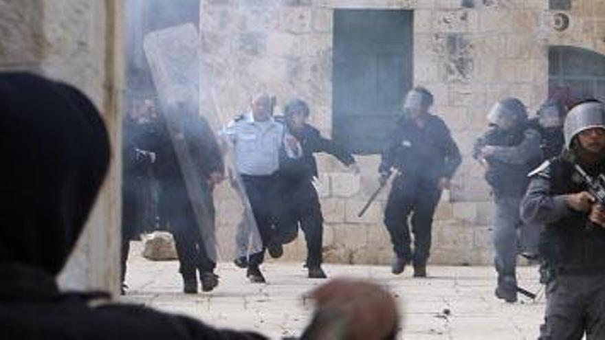 Un plaestino tira una piedra a las fuerzas de seguridad israelíes.