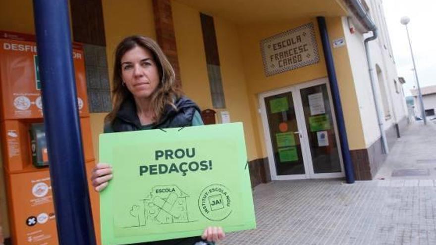 La portaveu de les famílies, Irene Antolín, amb un cartell reivindicatiu, ahir, davant l&#039;escola.