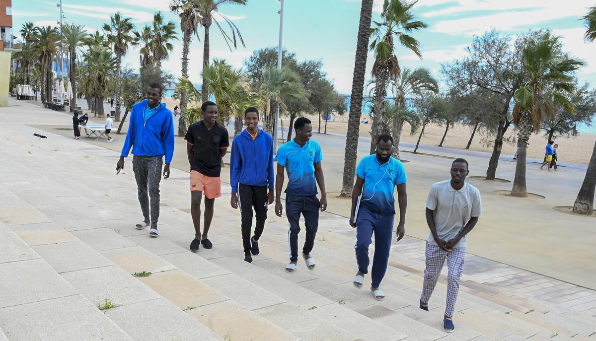 Mohamadou O., Ibrahim, Mahamadou, Mamadou, Mohamadou G y Diougouba, procedentes de Mali, conversando cerca de la playa de Badalona este miércoles.
