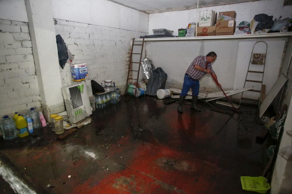 Trabajos de limpieza en la calle Llano Ponte de Avilés tras las inundaciones