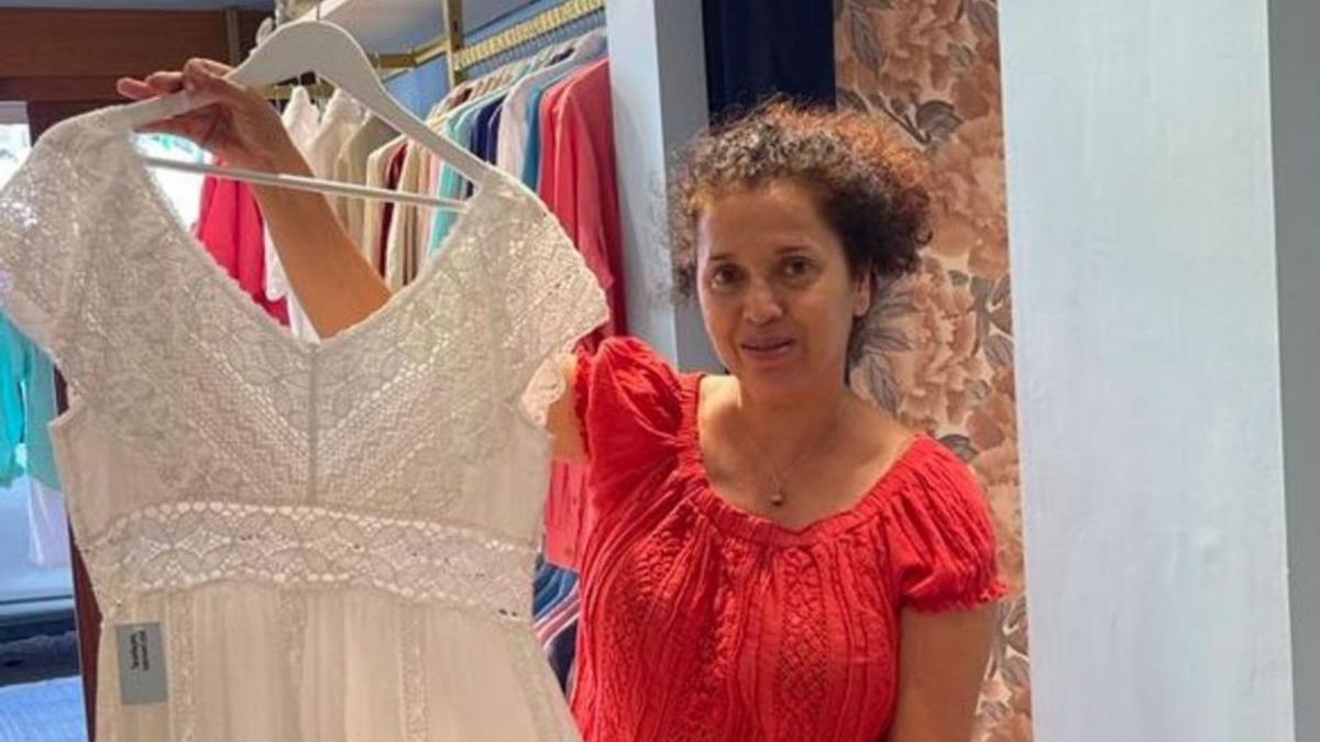 Carmen, empleada de una tienda de moda adlib, sostiene uno de los vestidos. 