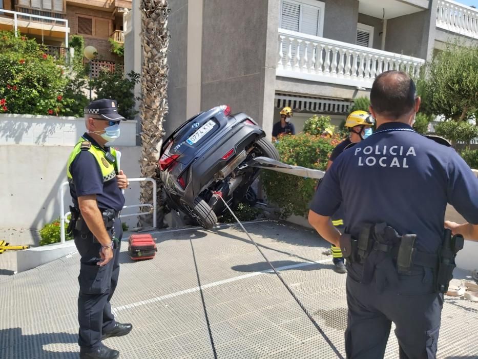 Dos ocupantes de un vehículo han sido rescatados por los bomberos de Alicante tras quedar su coche suspendido entre una palmera y una pared en el acceso de una urbanización de Alicante.