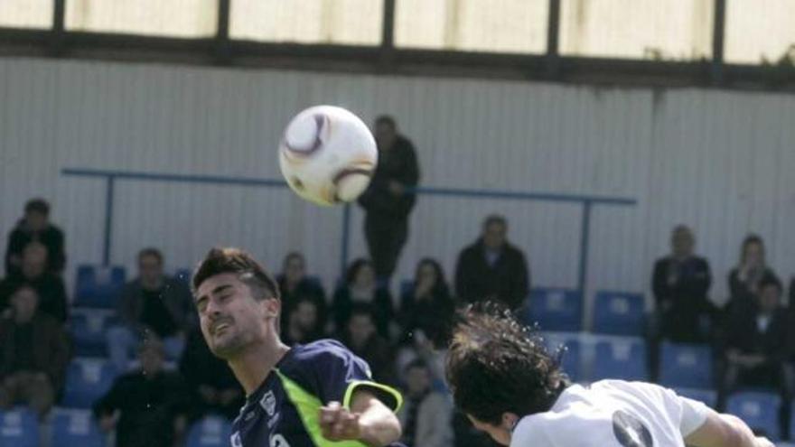 Sergio Prendes disputa un balón de cabeza con Adrián Cruz.