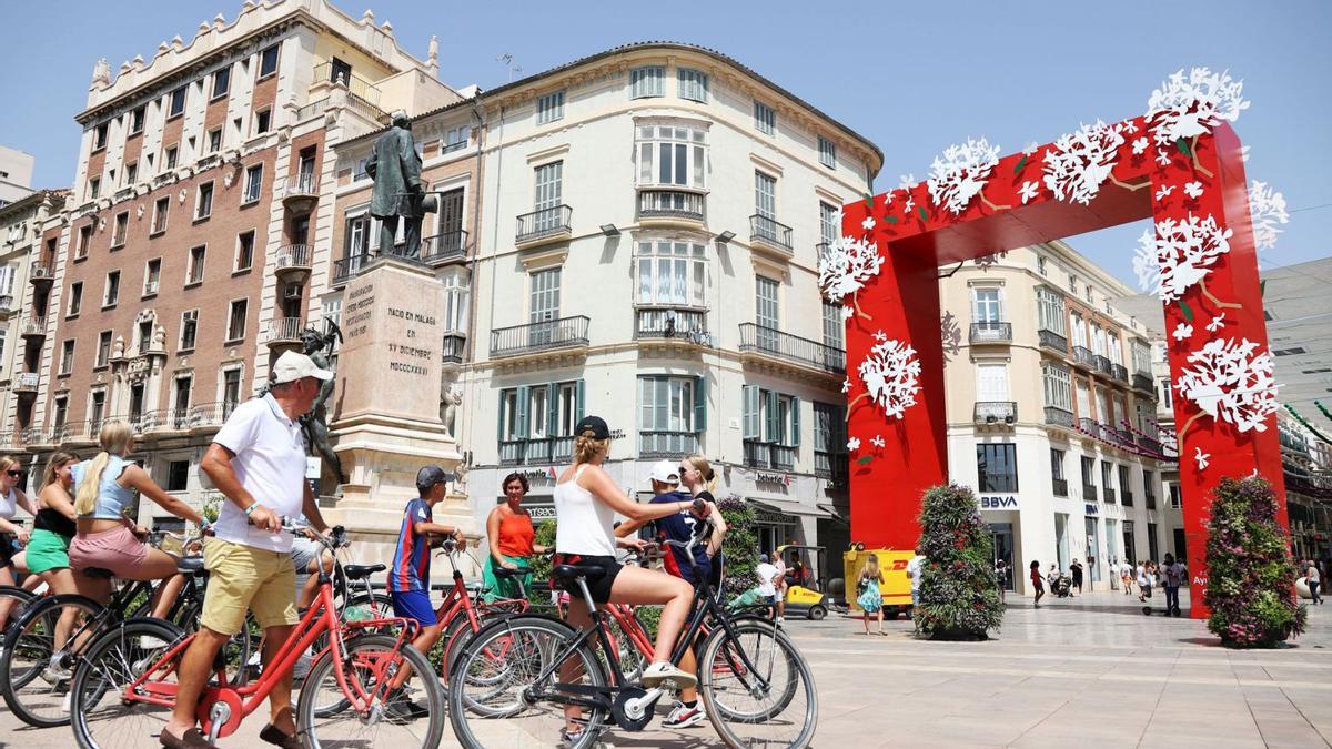 Turistas ante la portada de la Feria de Málaga en la calle Larios.