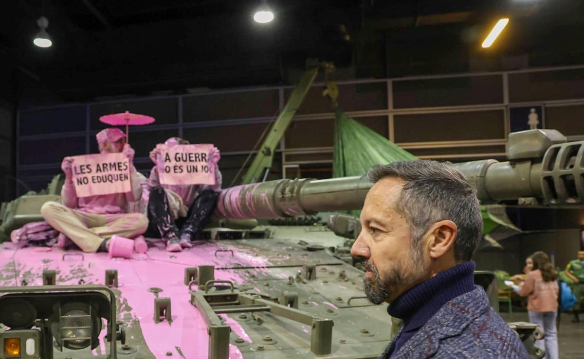Unos pacifistas rocían pintura rosa sobre una tanqueta en Expojove: "Las armas no educan"
