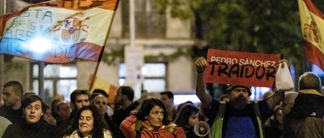 Varios manifestantes durante una manifestación contra la amnistía frente a la sede del PSOE en Ferraz