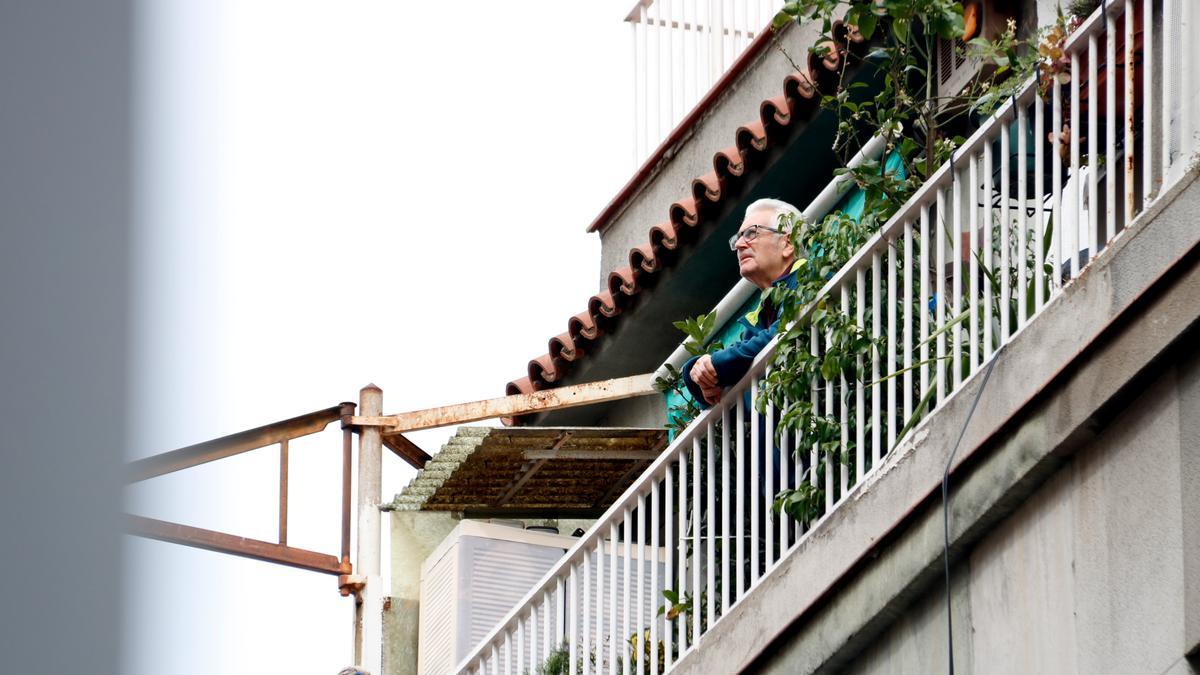 Un home mira cap al carrer des del balcó de casa, a Barcelona, el dia 18/03/2020