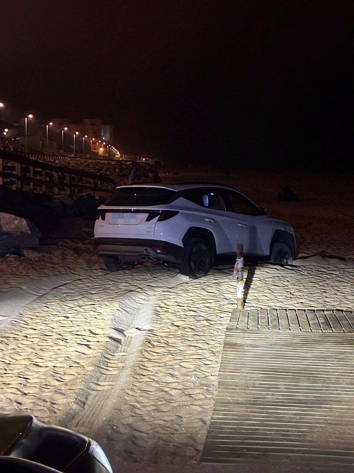 El coche aparcado en la arena de la playa.
