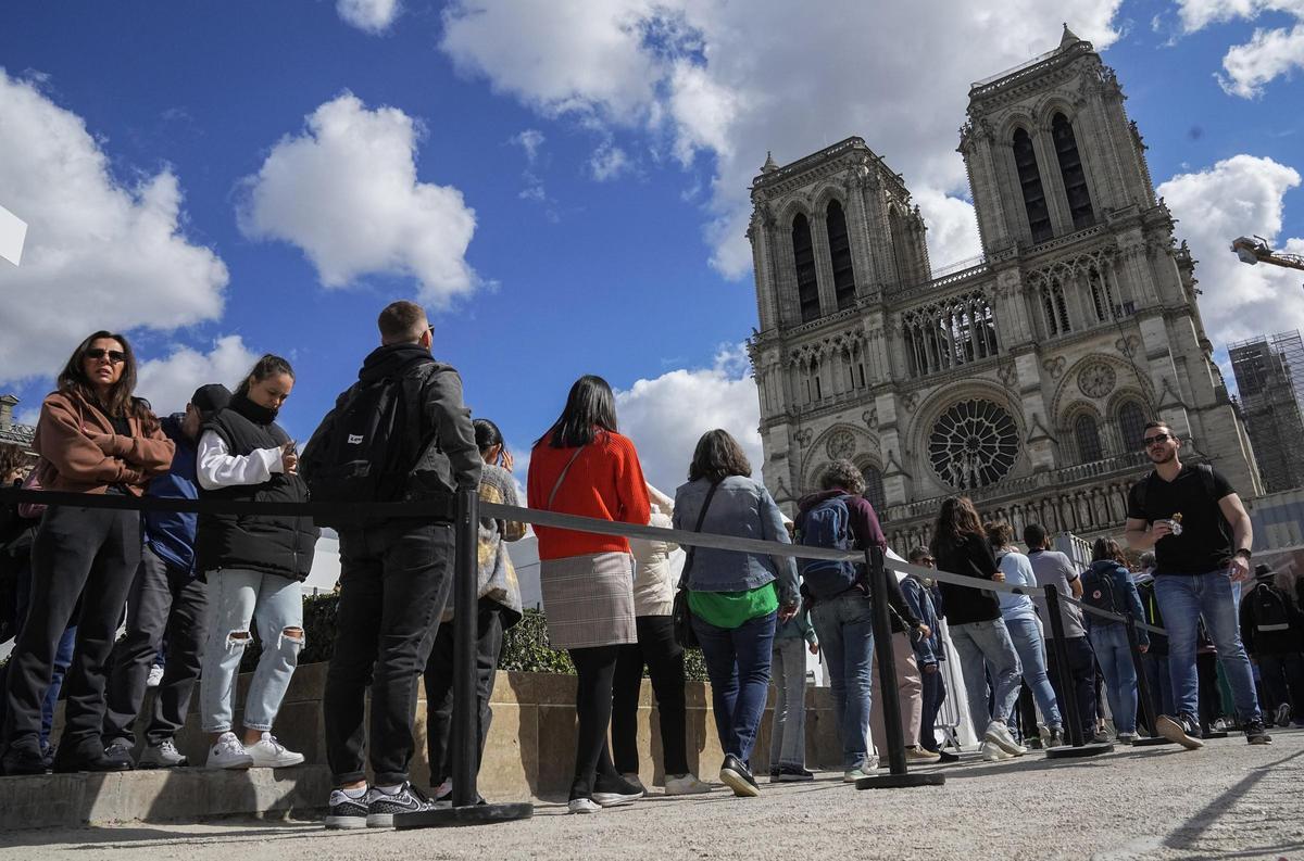Turistas en una cola a las afueras de Notre Dame (París).