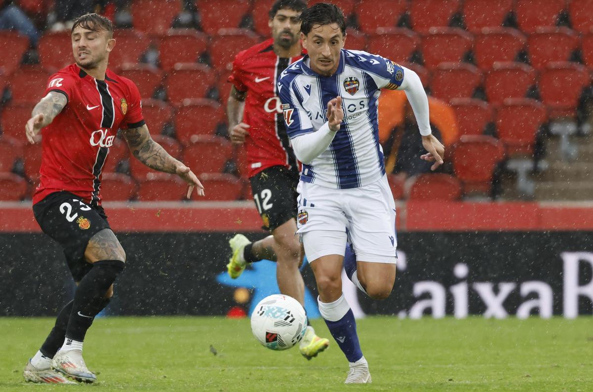 El centrocampista del Levante Pablo Martínez, ante el defensa del Mallorca Pablo Maffeo, bajo la intensa lluvia.