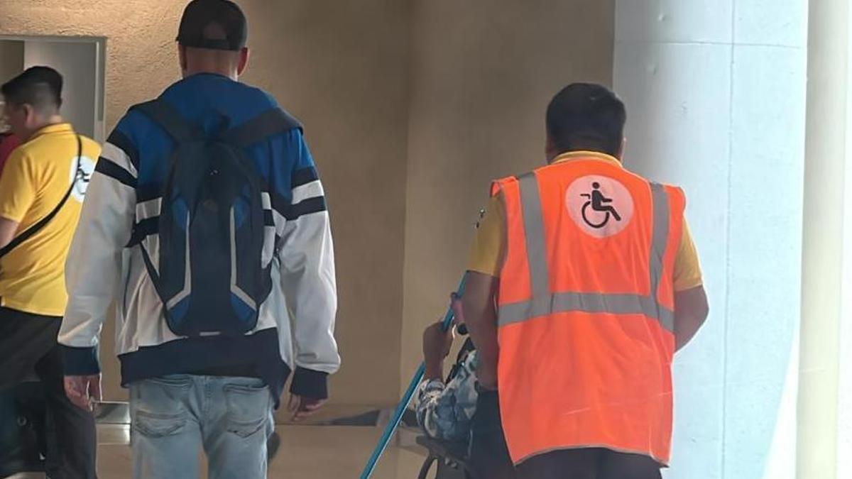 Un trabajador del servicio PMR traslada a un pasajero, este martes en el aeropuerto de Palma.