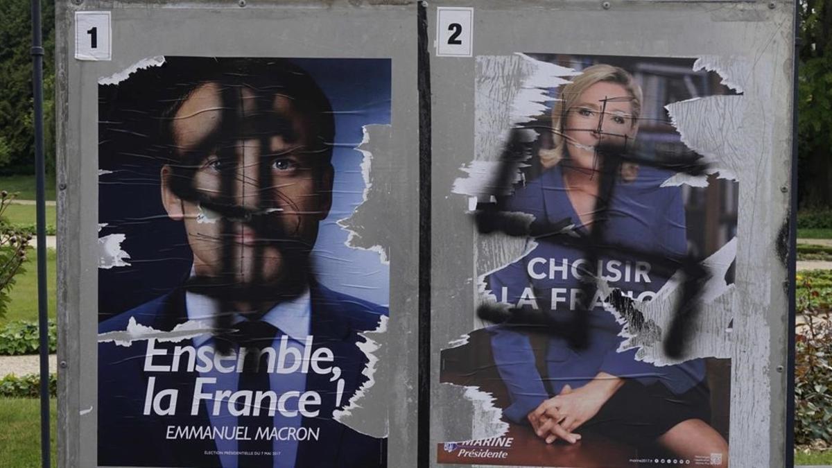 Pintadas en carteles electorales de Macron y Le Pen