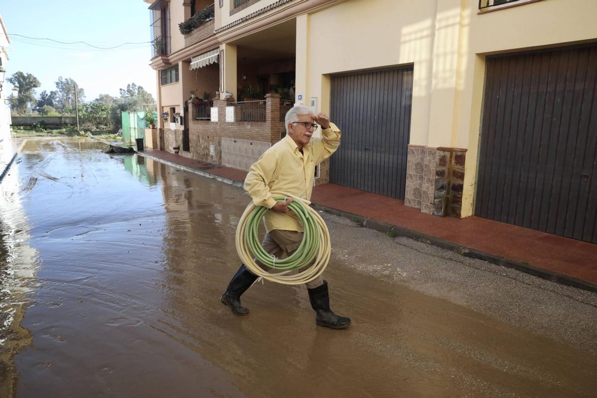 Los vecinos de la barriada de Doña Ana en la Estación de Cártama, junto al operarios Infoca, limpian los estragos de la nueva inundación provocada por la crecida del Guadalhorce durante la borrasca Francis