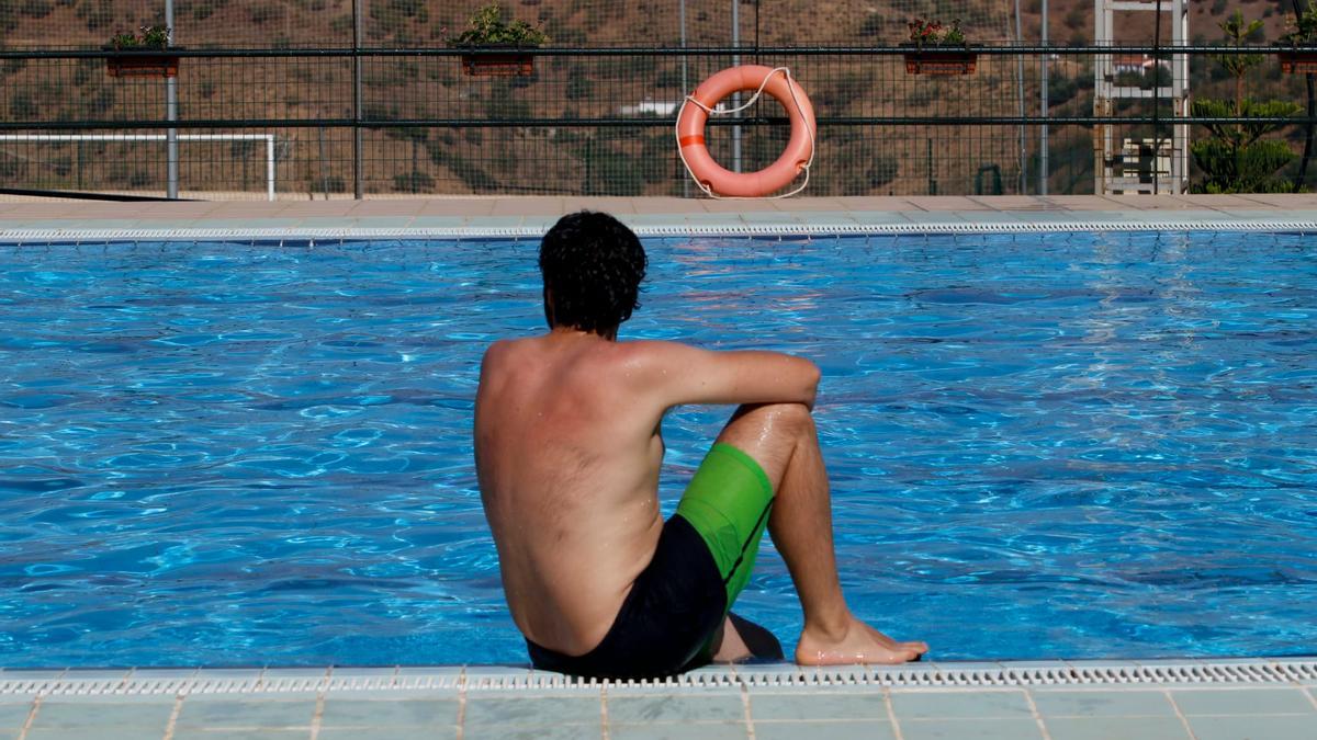 Un joven toma el sol en la piscina de Moclinejo, en la Axarquía