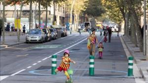 Una mujer con sus dos hijas, por la zona ganada al coche en Poblenou. 