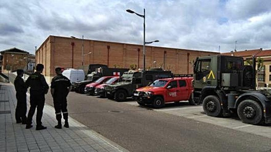 Un responsable de la UME observa con miembros de la Guardia Civil la flota de vehículos de la unidad.