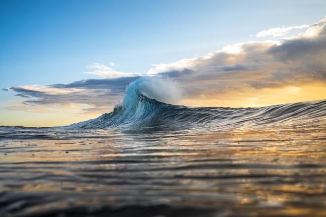 Ola a punto de romper contra el mar.