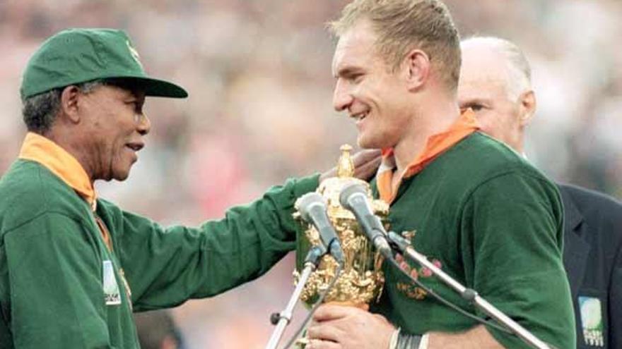 Mandela, con la camiseta de los Springboks, entrega el trofeo a Pienaar tras el triunfo de Suráfrica.