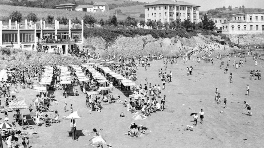 La playa de Luanco, en 1965, con el edificio de la conservera Pesquerías al fondo, a la derecha.