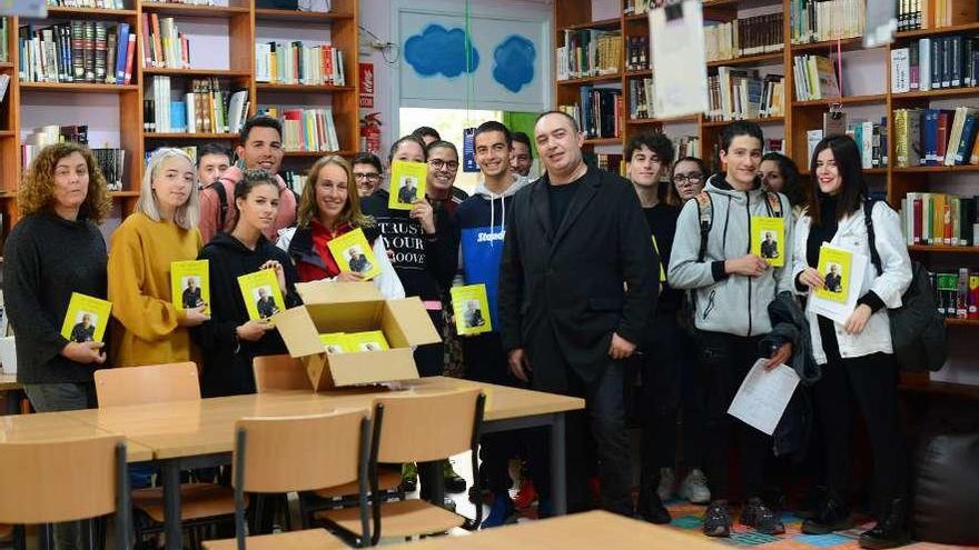 Alumnos del IES María Soliño enseñan el libro regalado por Ángel Bouzas (en el centro). // G. Núñez