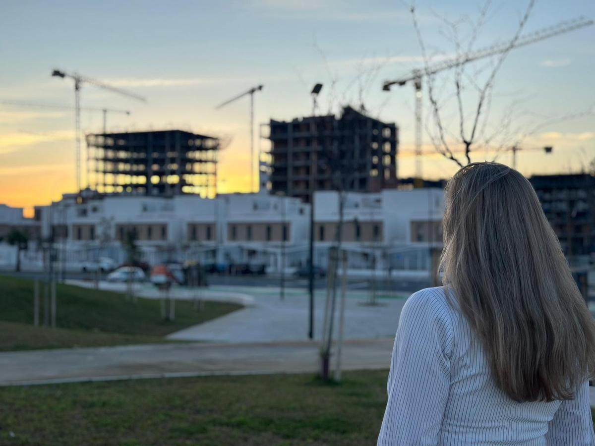 Una vecina de Palmas Altas contempla las construcciones del barrio desde el parque a orillas del río Guadaíra.