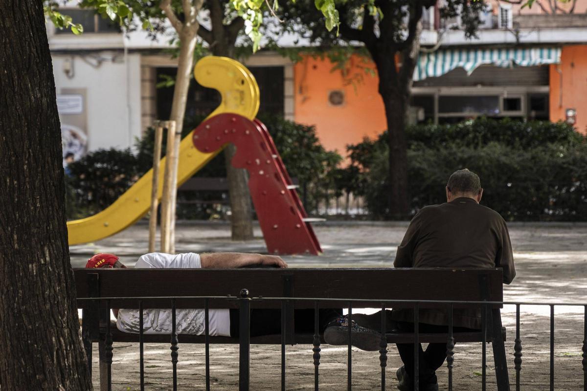 Dos vecinos del barrio descansan en un banco público