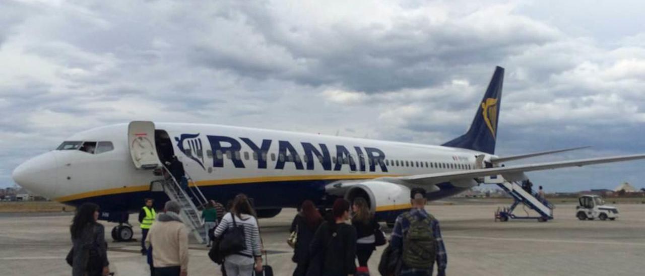 Varios pasajeros, dirigiéndose a un avión de Ryanair con destino a Londres, en el aeropuerto de Cantabria