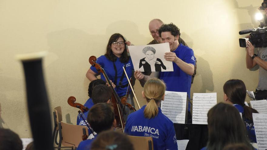 El director de orquesta recibe un regalo de los niños y niñas que participan en el proyecto.