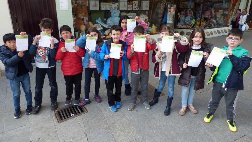 Alumnos del colegio Maestro Casanova muestran la lista del tipo de basura que se han encontrado en la villa de Cangas del Narcea.
