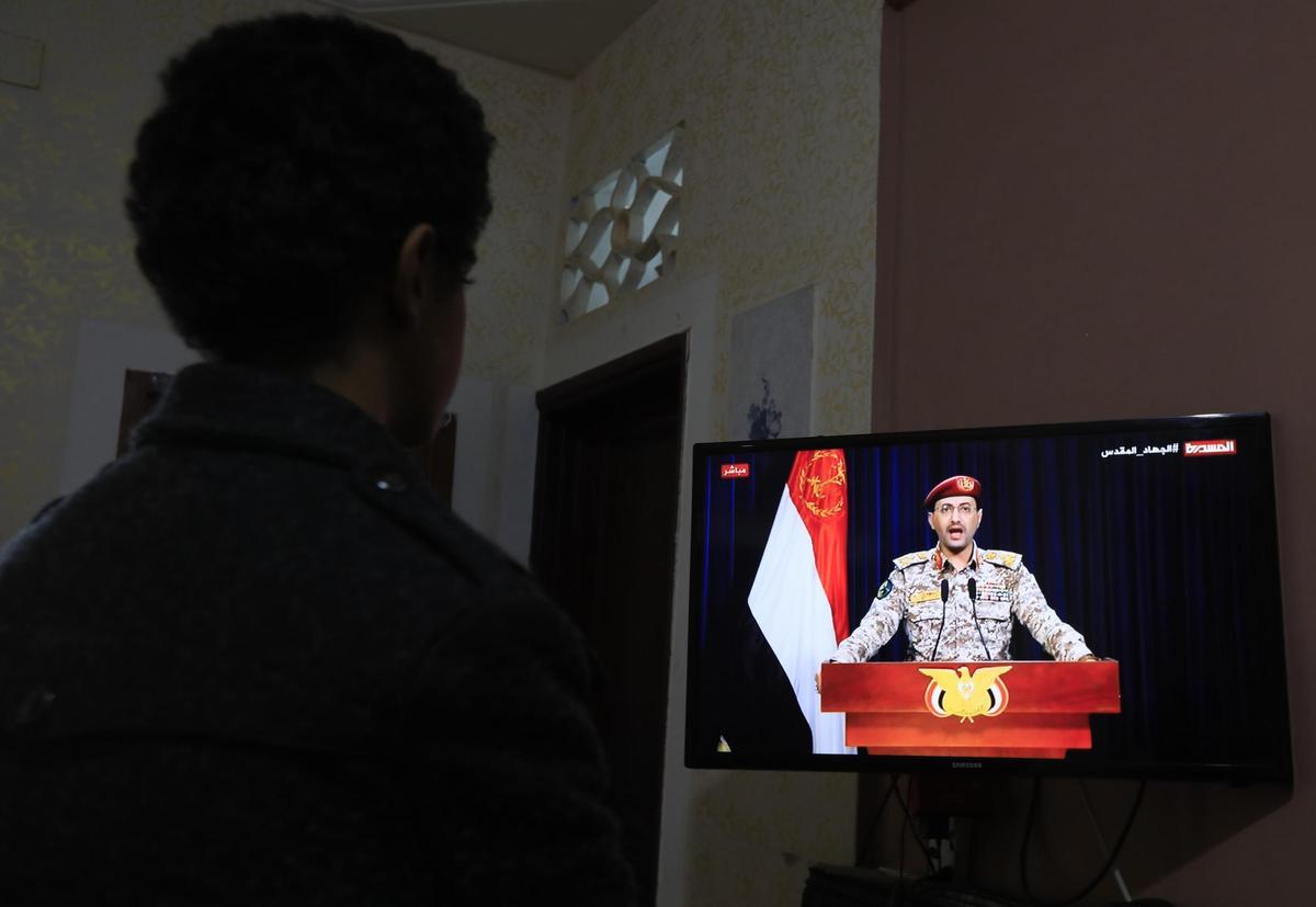 Una persona mira en la televisión, en Saná, la declaración del portavoz militar de los hutíes, Yahya Sarea, después de los ataques de Estados Unidos y el Reino Unido en Yemen