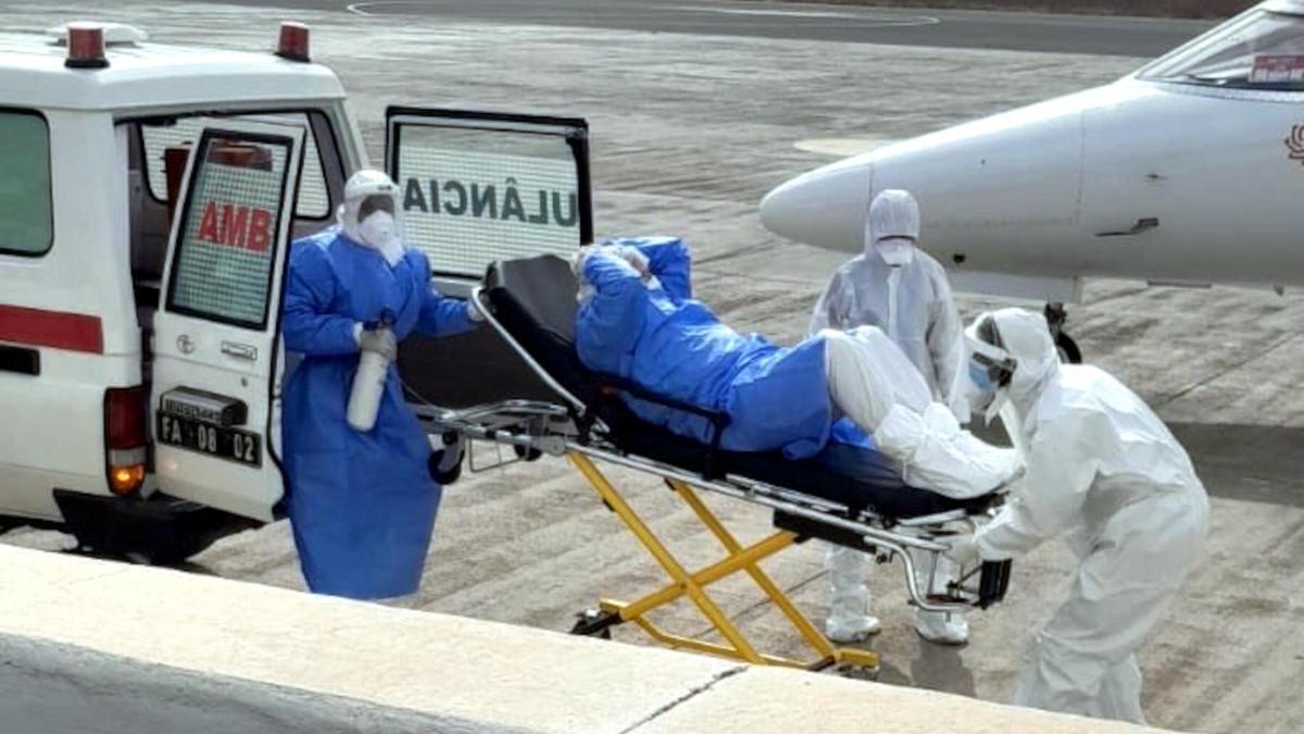 Sanitaris traslladen un malalt d'hantavirus d'una ambulància a un avió medicalitzat.