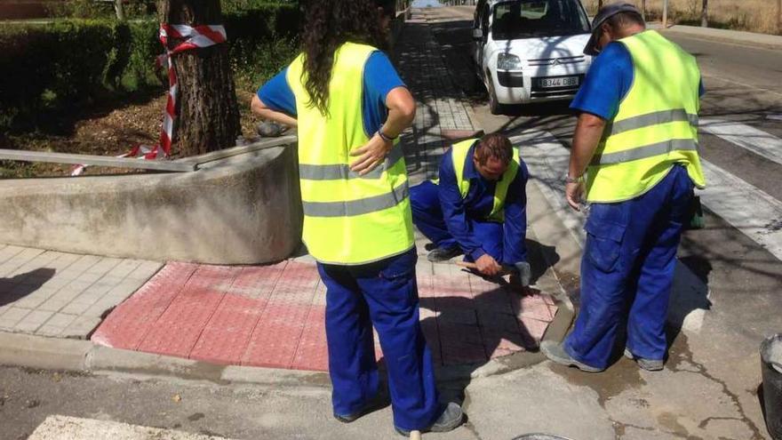 Operarios arreglan una acera en una de las calles de Benavente.