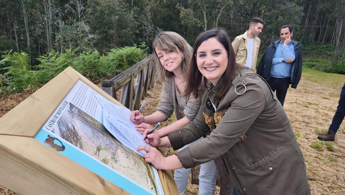 María Deza y Leticia Santos, firmando el acta de conformidad en el yacimiento.