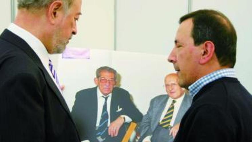 Gabino de Lorenzo, con Luis Martín, frente a una fotografía de Manuel F. Avello y José María Martínez Cachero, ayer, en Libroviedo.