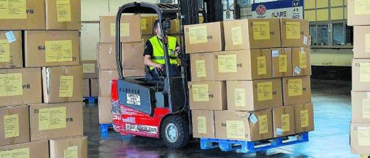 Un operario apila cajas de material sanitario tras desembarcarlas en el aeropuerto de Gran Canaria.