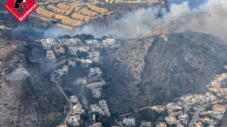 Los bomberos sofocando el incendio en la cala Llebeig de Marina Alta