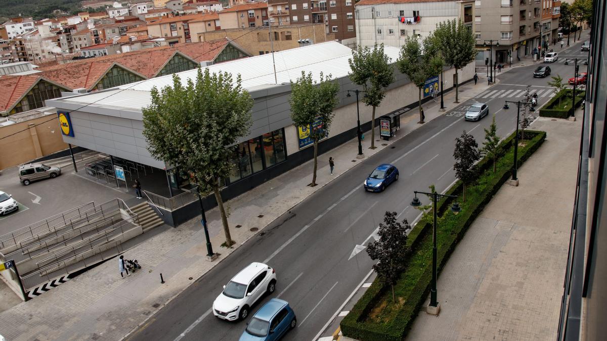 Vehículos bajando por el tramo inicial de la calle, de sentido único y que hace una pequeña curva.