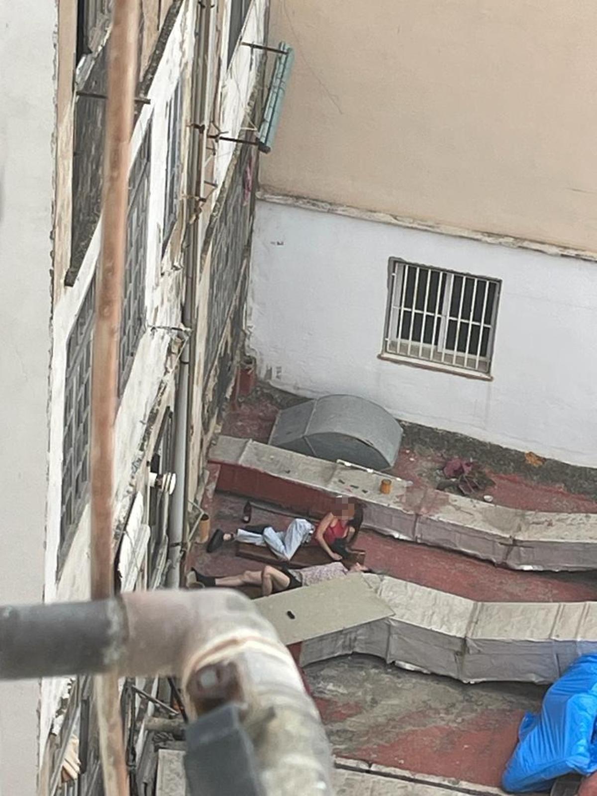 Dos personas tumbadas en las cubiertas interiores de una manzana del barrio de Morvedre.