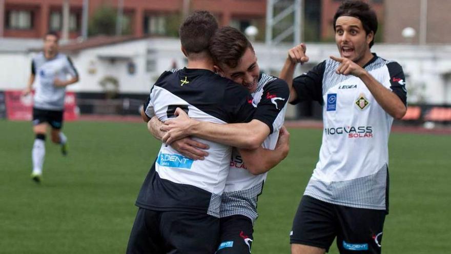 Pelayo abraza a Iván Fernández tras marcar un tanto, con David González acercándose.