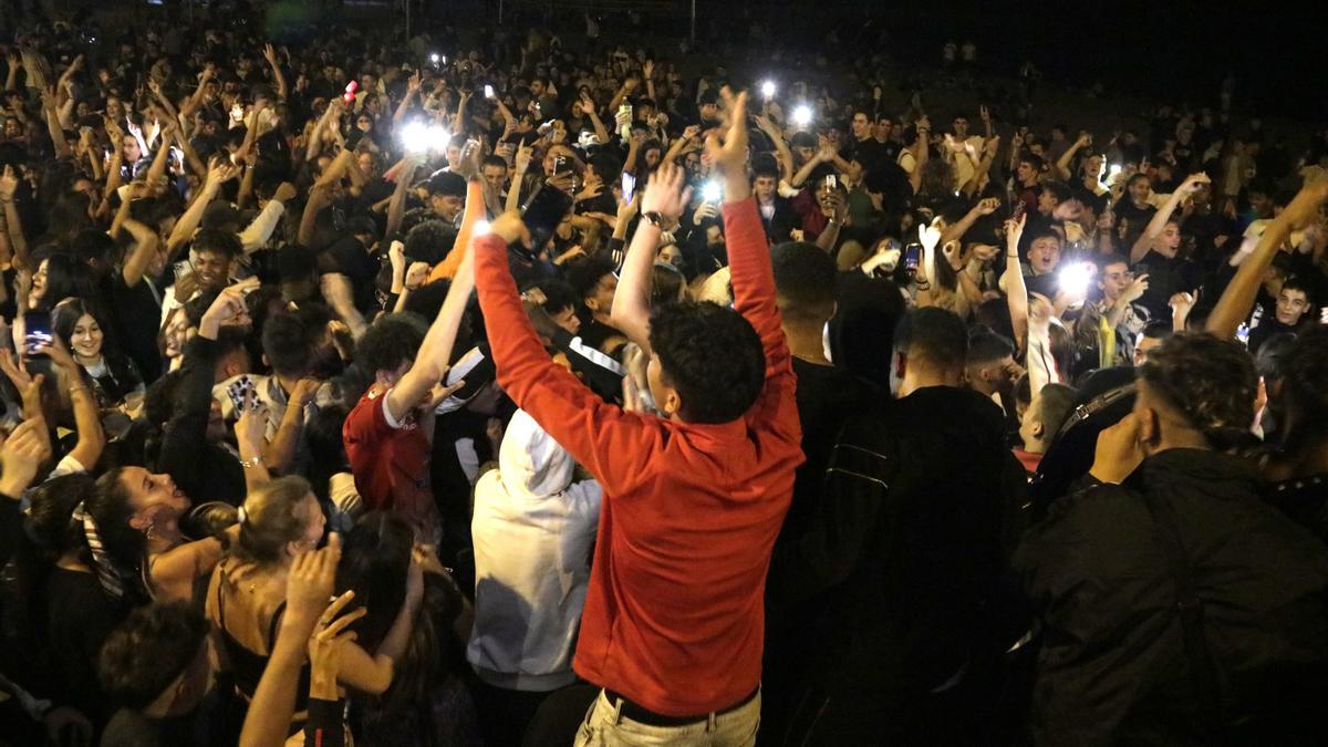 Un nombrós grup de joves ballant a la platja del Bogatell de Barcelona.