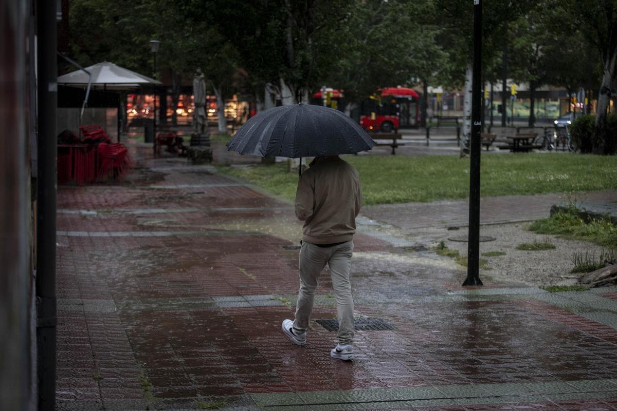 Un hombre se protege de la lluvia con un paraguas
