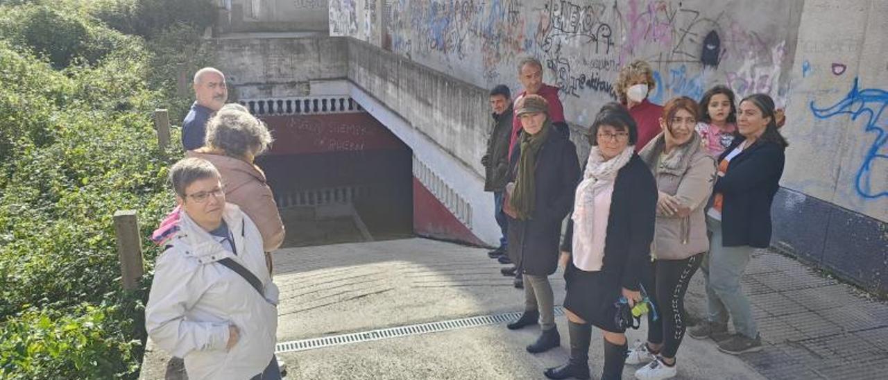 Algunos de los vecinos afectados, ayer, en la entrada de los garajes, completamente anegada. | G.N.