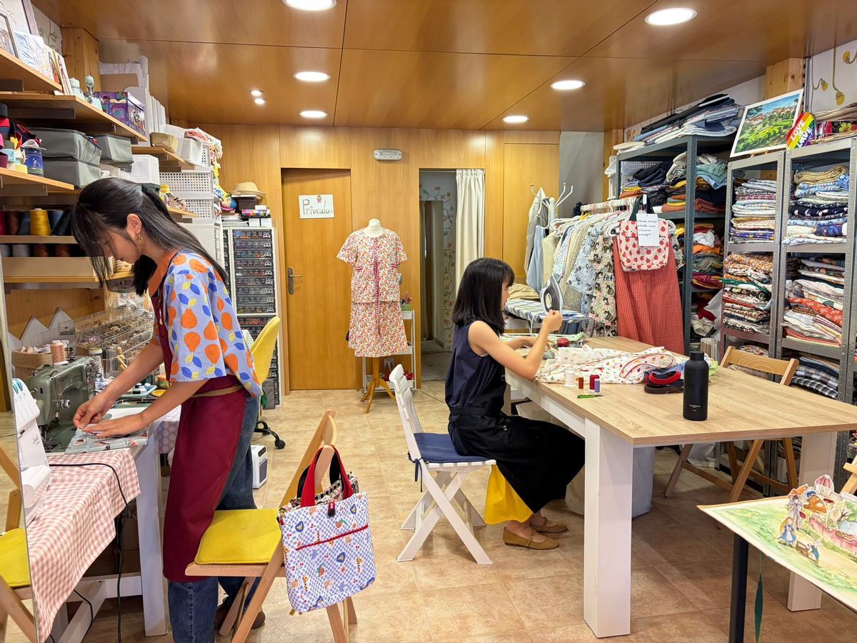 Sixing y Siyi trabajando en su estudio de arte y moda en O Milladoiro.